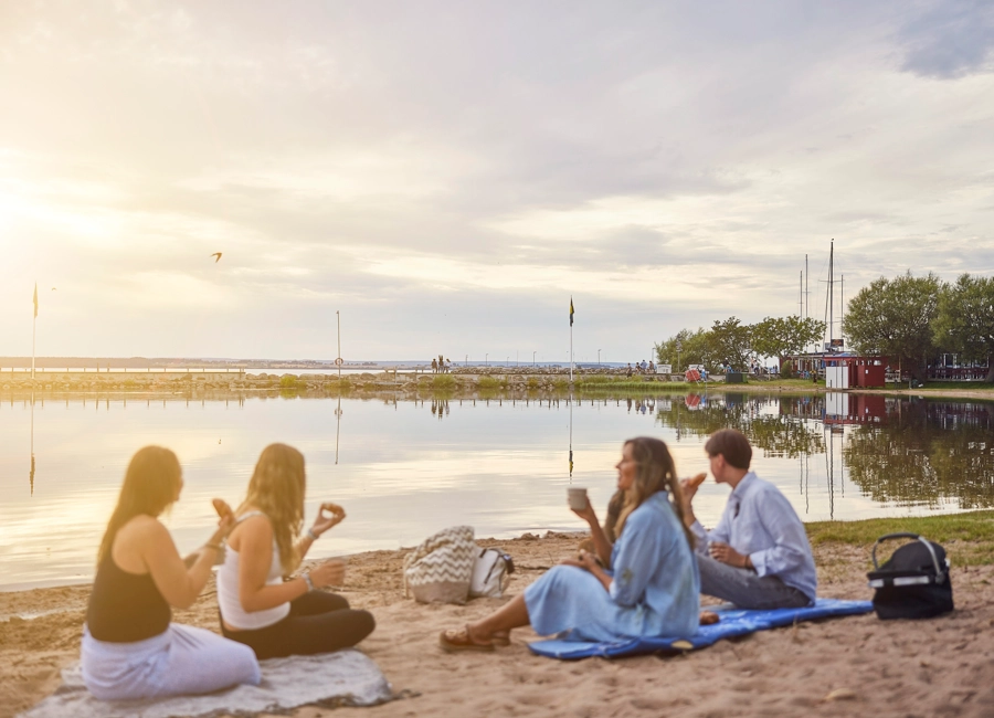 Människor som slagit läger och äter i det fria